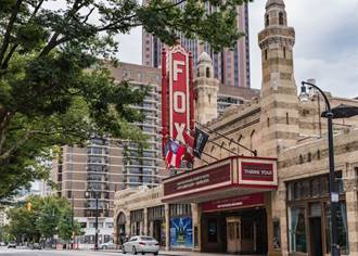 A picture containing text, outdoor, building, tree

Description automatically generated